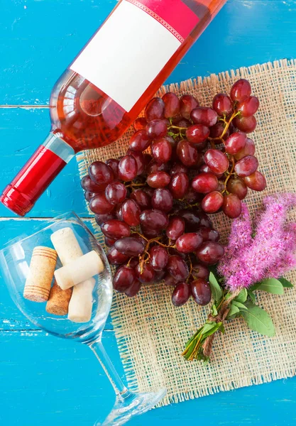 Demet taze olgun kırmızı üzüm ve mavi ahşap dokusal yüzeyi gül şarabı. metin reklam alanı