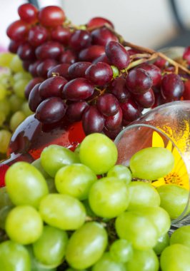 Demet taze farklı olgun üzüm ve bir şişe kırmızı şarap bir mavi ahşap dokusal yüzeyinde. metin reklam alanı