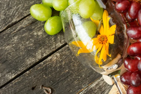 Demet taze farklı olgun üzüm ve bir şişe kırmızı şarap bir mavi ahşap dokusal yüzeyinde. metin reklam alanı