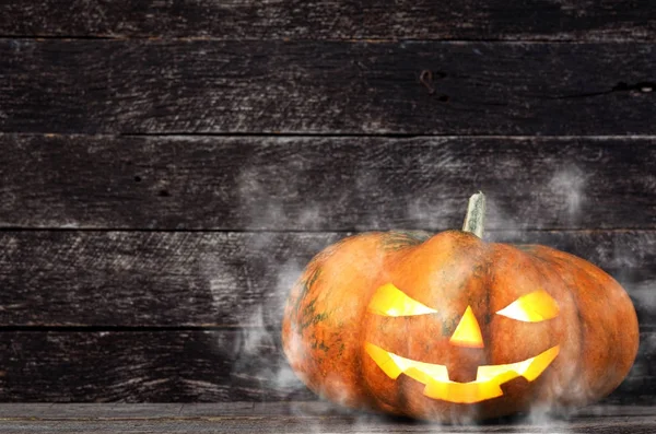 Kísérteties Halloween sütőtök fej jack lantern körülvett szellemek a ködben, fából készült háttér — Stock Fotó