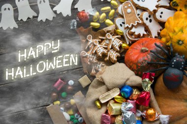 Mutlu Cadılar Bayramı kartı. Komik lezzetli zencefilli kurabiye şekli hayalet ve iskelet, tatlılar ve şeker kabaklar ve tatlılar ile çanta.