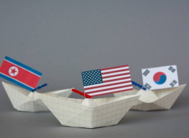 Kağıt gemi ABD bayrakları ve Kuzey Kore. Japon Denizi, kavram sevk irsaliyesi veya serbest ticaret anlaşması ve üyelik çatışma.