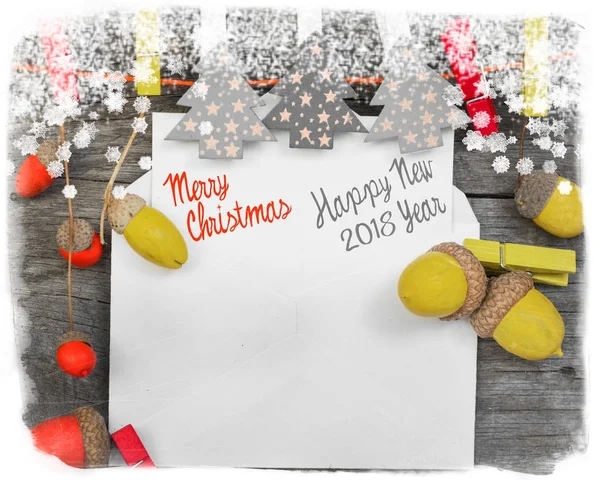 Merry Christmas and Happy New Year card with space for wish text. made from handicraft garland of colored acorns, decorative toys and a wooden christmas-tree. — Stock Photo, Image