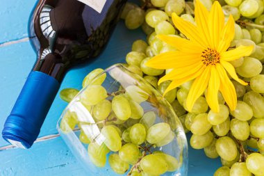 Demet taze olgun beyaz üzüm ve şarap bir mavi ahşap dokusal yüzeyinde. metin reklam alanı