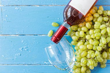 Demet taze olgun beyaz üzüm ve şarap bir mavi ahşap dokusal yüzeyinde. metin reklam alanı