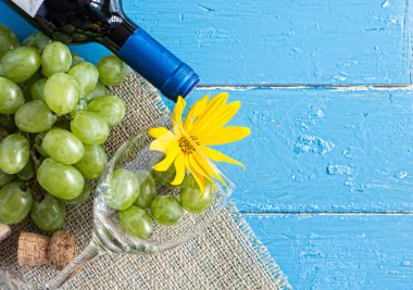 Demet taze olgun beyaz üzüm ve şarap bir mavi ahşap dokusal yüzeyinde. metin reklam alanı