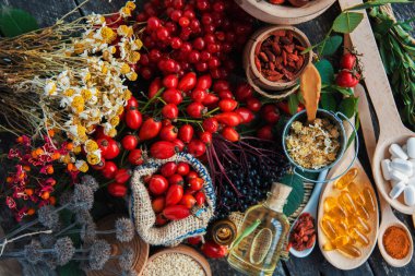 Medicinal tablets and pills and herbs composition: Dog rose, bunch branch Rosehips, types Rosa canina hips, essential oil. bunch, dried flowers of linden and chamomile elderberries and goji berries. clipart