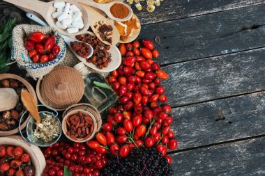 İlaç tabletleri, haplar ve şifalı bitkiler: köpek gülü, dal biberler, Rosa kanina kalçası, gerekli yağ. Bir demet kurutulmuş ıhlamur çiçeği ve papatya elderberry ve goji üzümü..