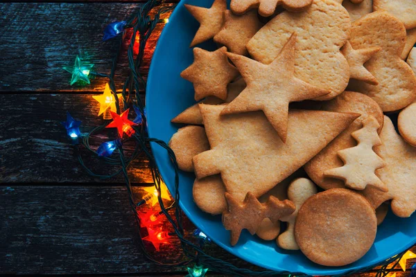 Lezzetli tatil Gingerbread çerezleri ahşap masa ile plaka. Mutlu Noeller ve mutlu yeni yıl kartı
