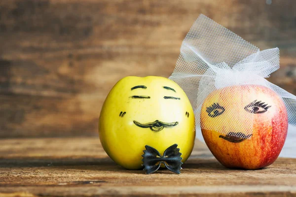 apple painted with the bride and groom. Face on an apples. Apple family. the concept of social relations. society. toned color image