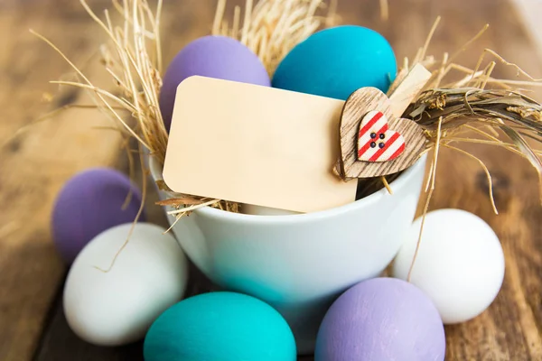 Easter eggs in nest on wooden background, selective focus image. Happy Easter card