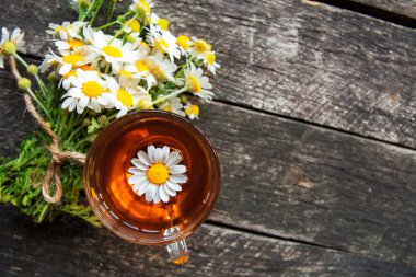 ahşap arka plan üzerinde taze papatya çiçekler ile bitkisel papatya çayı fincan. Doktor tedavi ve Önleme kavramının bağışıklık, tıp - halk, alternatif, tamamlayıcı, geleneksel tıp 