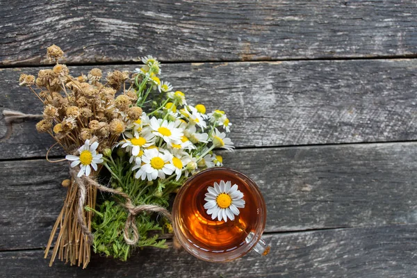 cup of herbal chamomile tea with fresh daisy flowers on wooden background. doctor treatment and prevention of immune concept, medicine - folk, alternative, complementary, traditional medicine