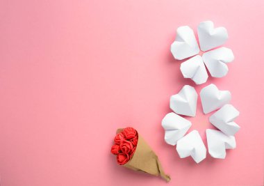 Kağıt kalpler, yumuşak pembe Uluslararası Kadınlar Günü kartında seksen sekiz şeklindedir.