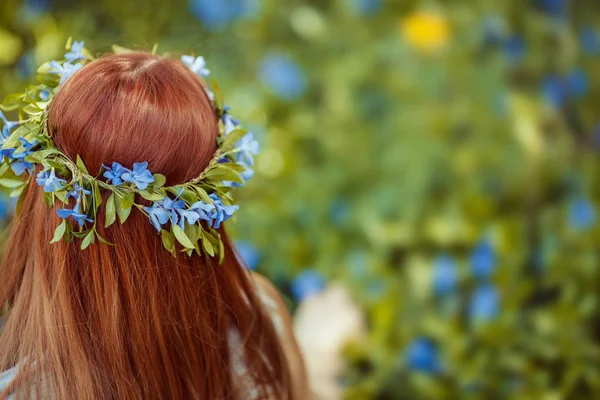 Chica sentada en el campo de periwinkle . — Foto de Stock