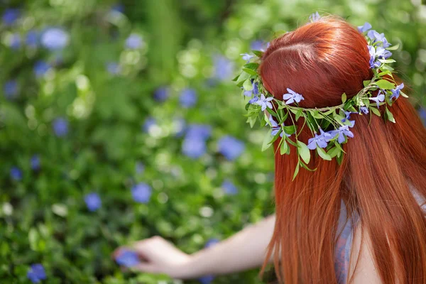 Chica sentada en el campo de periwinkle . — Foto de Stock