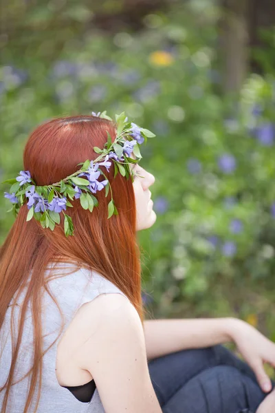 Meisje zittend op het veld maagdenpalm. — Stockfoto