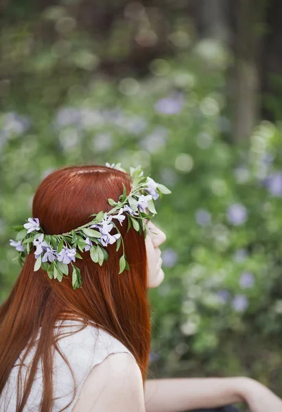 Chica sentada en el campo de periwinkle . — Foto de Stock