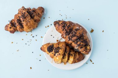 Açık mavi renkli üzerinde taze kruvasan. Metin, kopya alanı için yer. Düz yatıyordu. Üstten Görünüm.