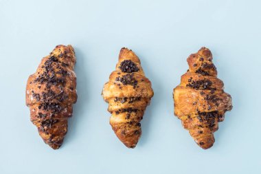 Açık mavi renkli üzerinde taze üç ay çöreği. Metin, kopya alanı için yer. Düz yatıyordu. Üstten Görünüm.