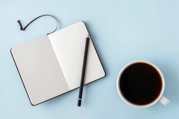 Masă albastră de birou cu notepad gol, creion și ceașcă albă de cafea. Copiați spațiul pentru text. Plat lay. Privire de sus . — Fotografie, imagine de stoc