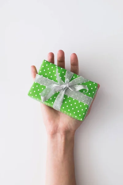 Mujer mano sosteniendo caja de regalo verde aislado sobre fondo blanco. Vista superior, cama plana. Espacio de copia . — Foto de Stock