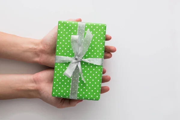 Жінка тримає зелену подарункову коробку ізольовано на білому тлі. Вид зверху, плоска лежала. Копіспазмі . — стокове фото