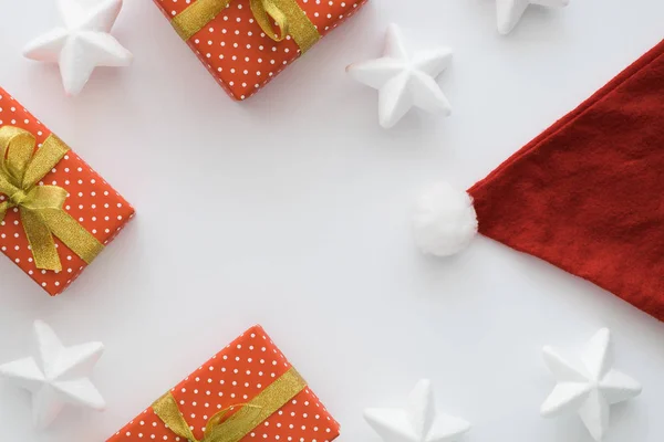 Новорічна та різдвяна святкова композиція з подарунковими коробками, капелюхом Санти, стрічками, зірками на білому тлі. Вид зверху, плоска лежала. Копіспазмі . — стокове фото