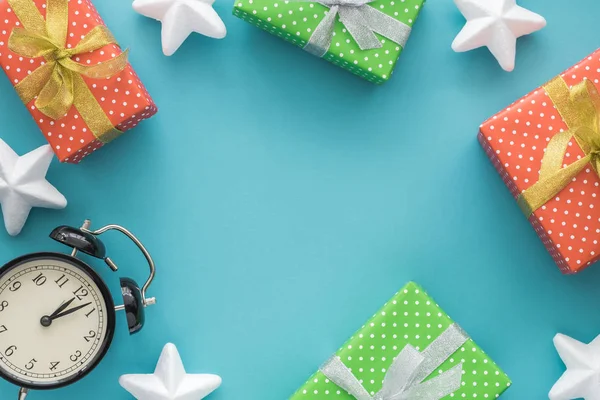 Різдвяна та новорічна святкова композиція з подарунковими коробками, зірками, годинником на синьому фоні. Вид зверху, плоска лежала. Копіспазмі . — стокове фото