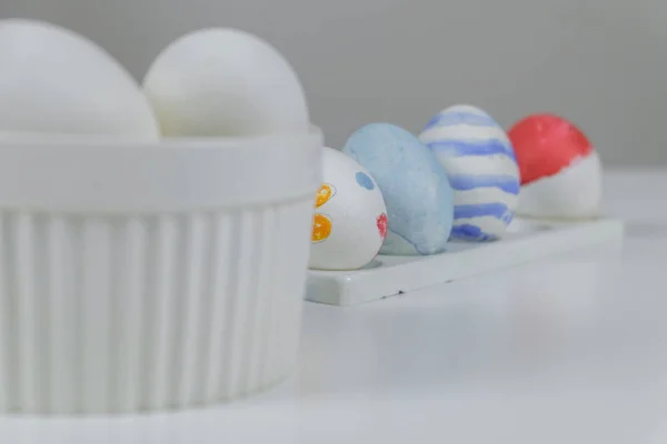 Une table avec des œufs blancs et colorés, préparés pour la décoration de Pâques . — Photo