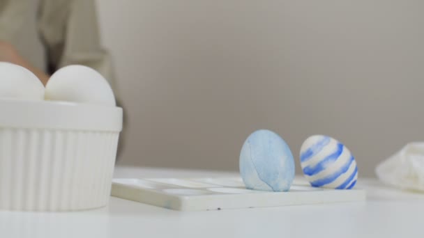 Mujer irreconocible pone un huevo de Pascua adornado en un estrado. Preparación para las vacaciones . — Vídeos de Stock