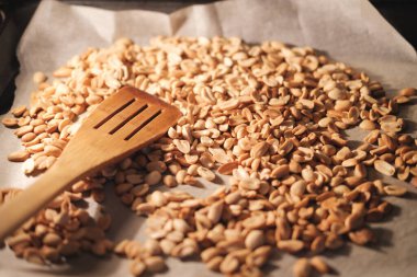 Fıstık çekirdekleri fırında pişer ve parşömen kağıdında kızarır. Evde ev yapımı fıstık ezmesi yapmaya hazırlanıyorum..