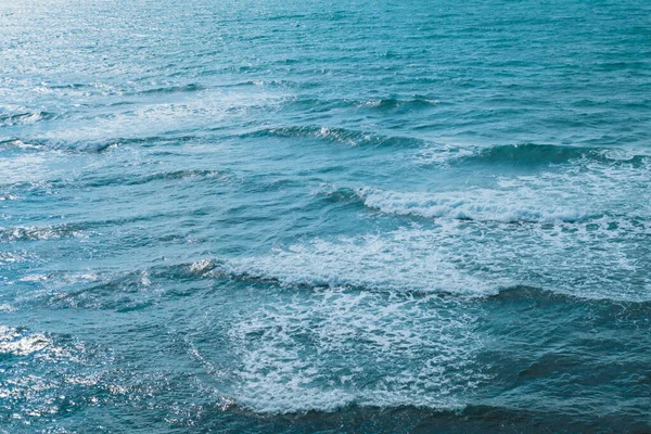 Textura do mar ou oceano com ondas de cordeiro branco rolando para a costa . — Fotografia de Stock