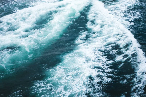 Mar ou oceano ondas textura superficial. Verão abstrato fundo de água azul com salpicos de espuma do mar . — Fotografia de Stock