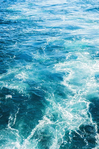 海や海の波の表面のテクスチャ。概要海泡の飛沫を伴う夏の青い水の背景. — ストック写真