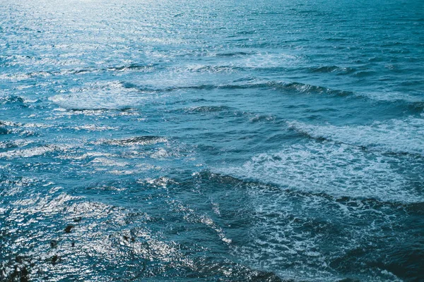 Texture de la mer ou de l'océan avec des vagues blanches d'agneau roulant sur le rivage . — Photo
