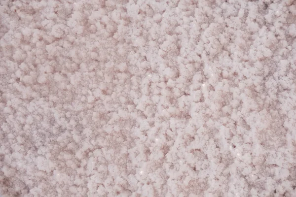 Ytan på en rosa saltsjö täckt med salt vid solnedgången. Härlig mjuk rosa konsistens. Närbild. — Stockfoto