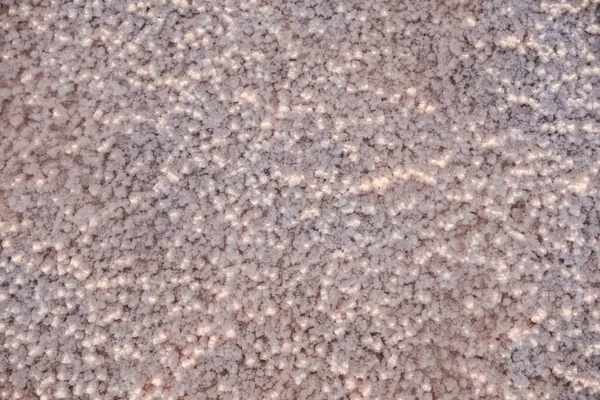 Het oppervlak van een roze zoutmeer bedekt met zout bij zonsondergang. Mooie zachte roze textuur. Sluiten. — Stockfoto