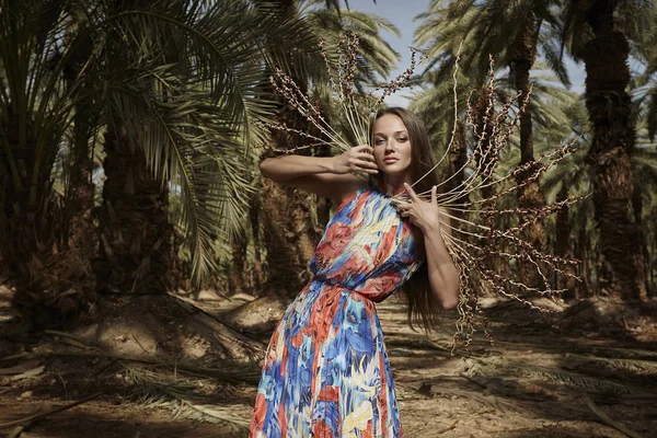 A menina em um belo modelo de vestido posando nas palmas das mãos . — Fotografia de Stock