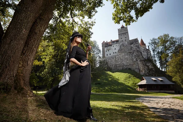 Modèle fille dans un chapeau et robe noire promenades dans la cour de th — Photo