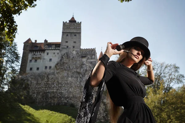 Modèle fille dans un chapeau et robe noire promenades dans la cour de th — Photo