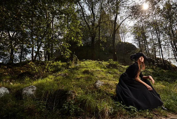 Model kız siyah elbise ve siyah şapka bir mistik yürüyüş 