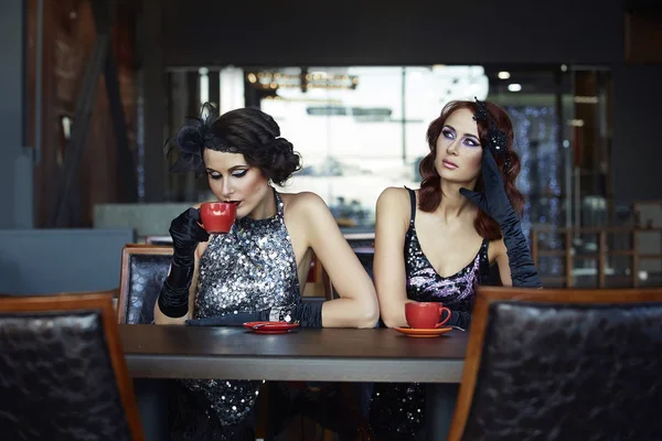 Δύο κορίτσια κάθονται σε ένα καφενείο και ποτό καφέ. — Φωτογραφία Αρχείου