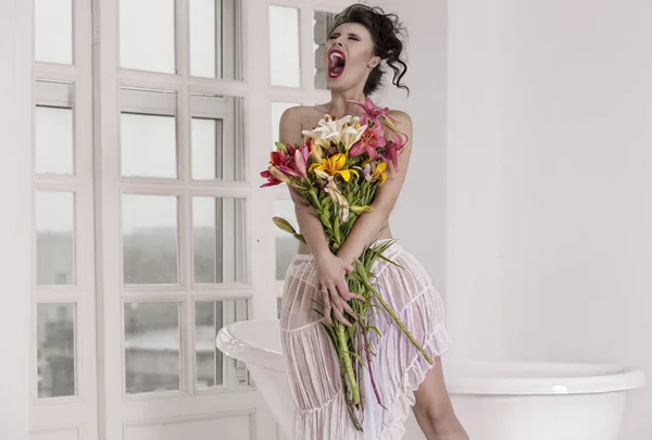 Uma menina com um lindo buquê de flores no banheiro . — Fotografia de Stock