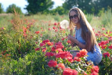 Kız, modeli güzel çiçekler ve enjo arasında bir çayırda elini kolunu sallaya dönüyor