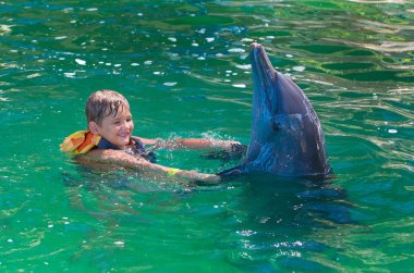 Bir çocuk, Bebek, manken yunuslarla yıkıyor. Adam, bir memeli bir do