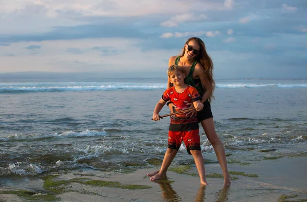 Μητέρα και γιος αναπαύονται στην παραλία κοντά στον ωκεανό. Οικογένεια v — Φωτογραφία Αρχείου