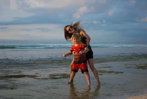 Μητέρα και γιος αναπαύονται στην παραλία κοντά στον ωκεανό. Οικογένεια v — Φωτογραφία Αρχείου