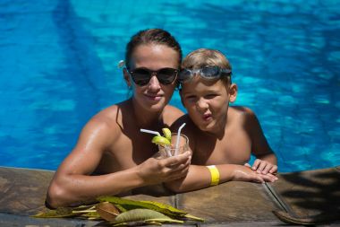 Birlikte anne ve oğlu havuzda sıcak bir yaz gününde bekletin. Chi