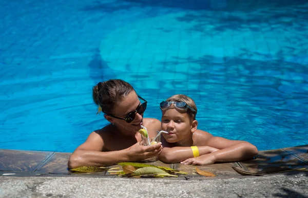 Mom and son rest together in the pool on a warm, summer day. Chi